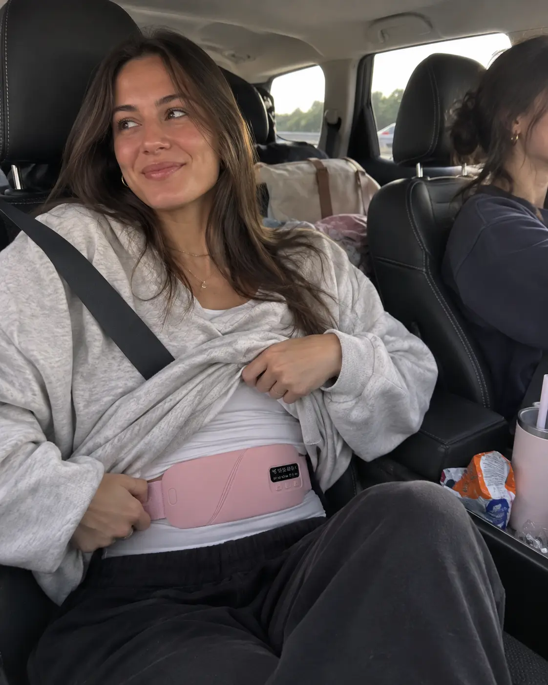 Woman wearing the MIRA Comfort Belt while riding in a car